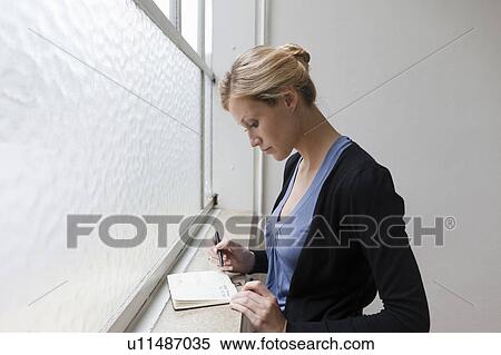 Stock Photography - Business woman reviewing her schedule. Fotosearch