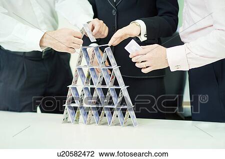 Stock Image - Businessman building house of cards. Fotosearch