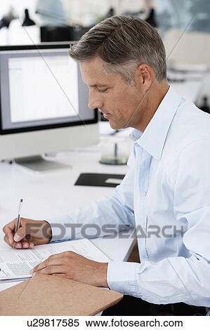 Businessman doing paperwork View Large Photo Image Stock Photography - Businessman doing paperwork. Fotosearch