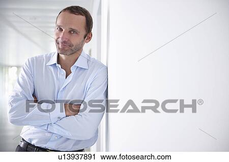 Businessman in an empty office, smiling View Large Photo Image Stock Image - Businessman in an empty office, smiling. Fotosearch