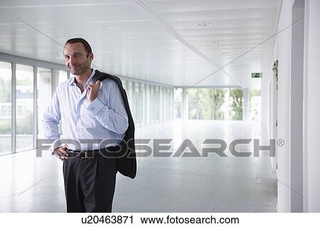 Businessman in an empty office, smiling View Large Photo Image Stock Image - Businessman in an empty office, smiling. Fotosearch