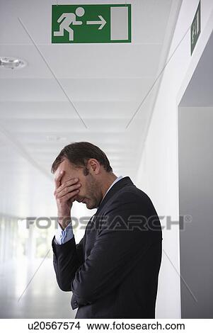Picture - Businessman in empty office, sad. Fotosearch