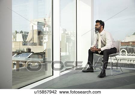 Businessman looking out of office window View Large Photo Image Stock Image - Businessman looking out of office window. Fotosearch