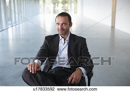 Businessman on a chair, in empty office View Large Photo Image Stock Image - Businessman on a chair, in empty office. Fotosearch