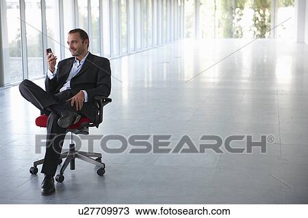 Businessman on a chair, in empty office View Large Photo Image Stock Image - Businessman on a chair, in empty office. Fotosearch