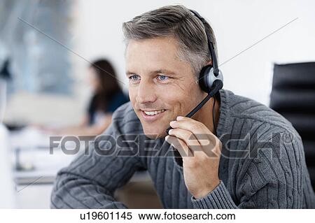 Stock Photography - Businessman phoning with headset. Fotosearch