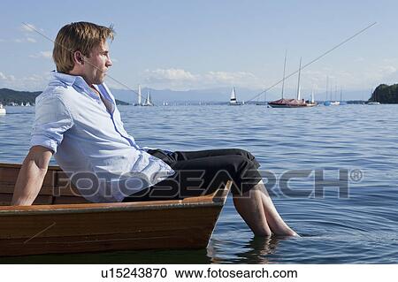 Businessman relaxing on a rowboat View Large Photo Image Stock Image - Businessman relaxing on a rowboat. Fotosearch