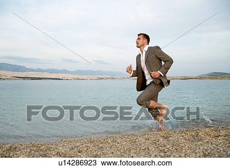 Businessman running on the beach View Large Photo Image Stock Image - Businessman running on the beach. Fotosearch