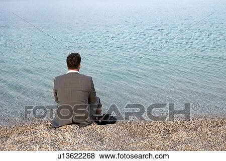 Businessman sitting on the beach View Large Photo Image Stock Photo - Businessman sitting on the beach. Fotosearch