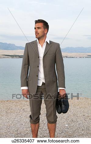 Businessman standing on the beach View Large Photo Image Stock Photo - Businessman standing on the beach. Fotosearch