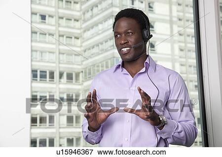 Businessman talking on telephone headset View Large Photo Image Stock Photo - Businessman talking on telephone headset. Fotosearch