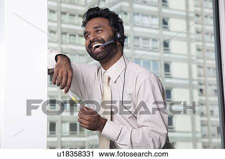 Stock Image - Businessman using telephone headset. Fotosearch