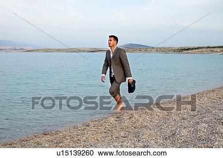 Businessman walking on the beach View Large Photo Image Stock Image - Businessman walking on the beach. Fotosearch