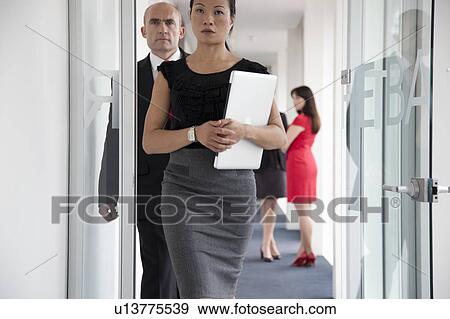Stock Photo - Businesspeople walking down corridor. Fotosearch