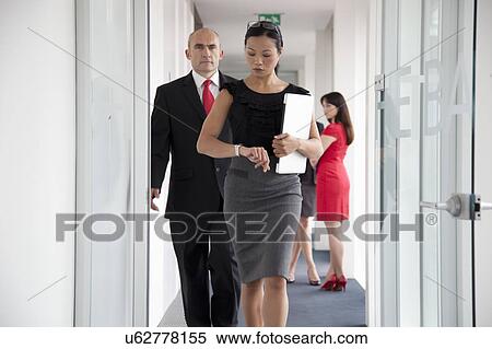 Stock Photography - Businesspeople walking down corridor. Fotosearch