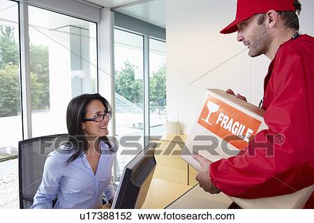 Stock Image - Businesswoman receiving a package. Fotosearch