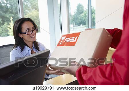 Stock Image - Businesswoman receiving a package. Fotosearch