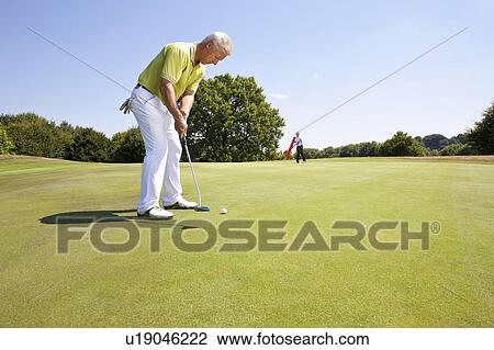 Caddy pointing at a hole on golf course View Large Photo Image Stock Image - Caddy pointing at a hole on golf course. Fotosearch