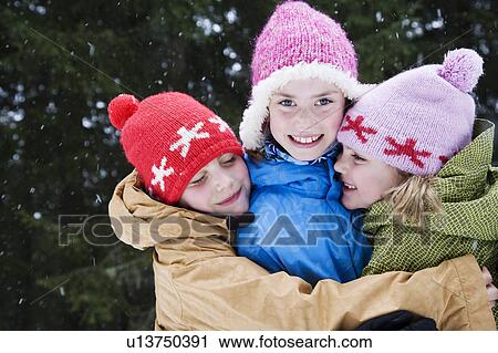 Stock Image - Children hugging in the snow. Fotosearch