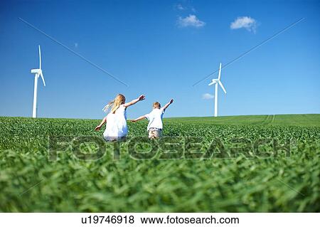 Stock Photo - Childrens play in field & wind turbines. Fotosearch