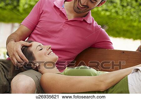 Close-up of couple relaxing on bench View Large Photo Image Stock Image - Close-up of couple relaxing on bench. Fotosearch