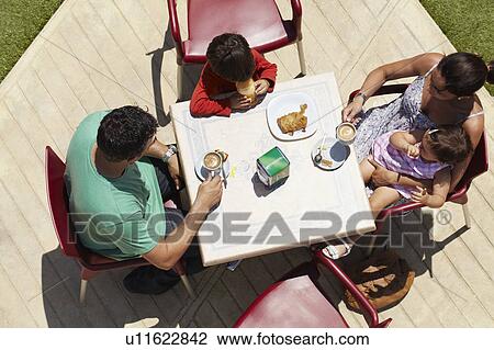 Close-up of family seated around table View Large Photo Image Stock Image - Close-up of family seated around table. Fotosearch