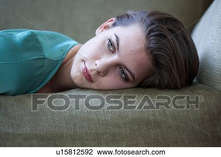 Stock Image - Close up of woman on sofa. Fotosearch