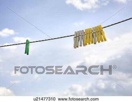 Stock Image - Clothes pegs hanging on washing line. Fotosearch