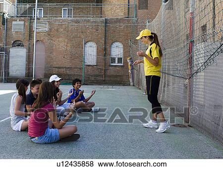 Coach and kids concentrating toghether View Large Photo Image Stock Photo - Coach and kids concentrating toghether. Fotosearch