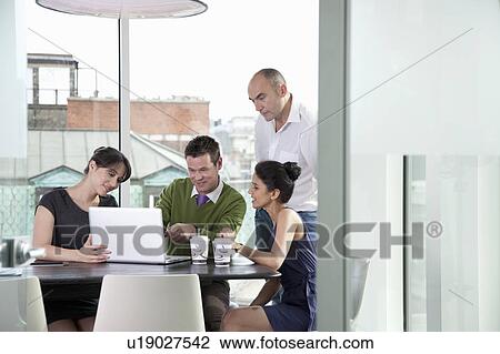 Colleagues looking at laptop View Large Photo Image Stock Image - Colleagues looking at laptop. Fotosearch