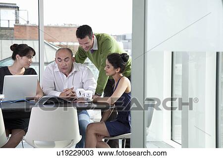 Stock Image - Colleagues taking conference call. Fotosearch