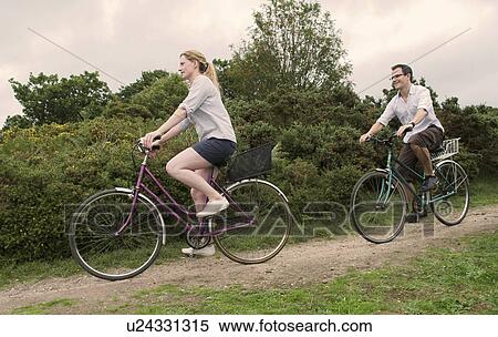 Couple bicycle over heath View Large Photo Image Stock Photography - Couple bicycle over heath. Fotosearch