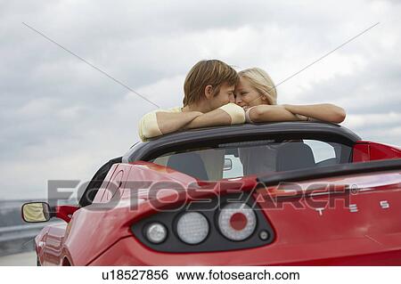 Couple close together in an electric car View Large Photo Image Stock Photograph - Couple close together in an electric car. Fotosearch
