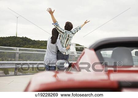 Couple close together near electric car View Large Photo Image Stock Photo - Couple close together near electric car. Fotosearch