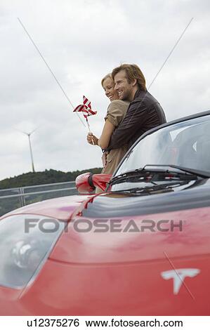Couple close together near electric car View Large Photo Image Stock Photograph - Couple close together near electric car. Fotosearch