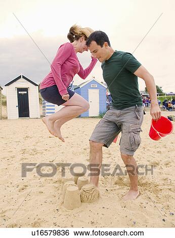 Couple destroy sandcastles View Large Photo Image Stock Photograph - Couple destroy sandcastles. Fotosearch
