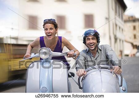 Stock Photography - Couple driving a vespa. Fotosearch
