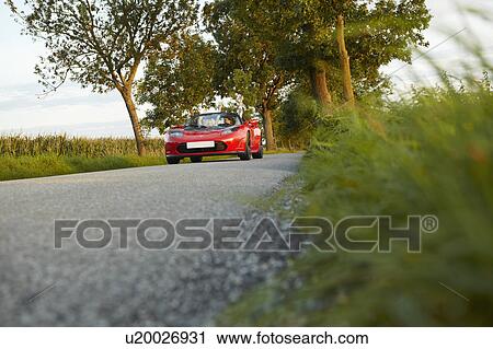 Couple driving an electric sports car View Large Photo Image Stock Image - Couple driving an electric sports car. Fotosearch