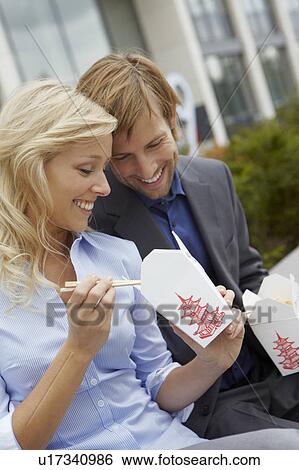 Stock Photograph - Couple eating chinese takeaway for lunch. Fotosearch