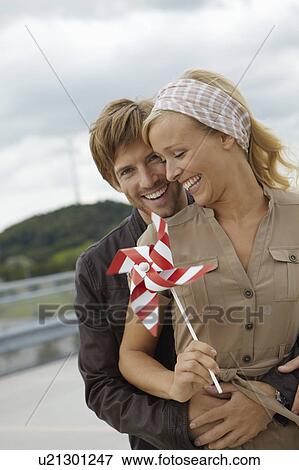 Couple holding handheld windmill View Large Photo Image Stock Photo - Couple holding handheld windmill. Fotosearch