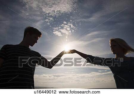 Couple holding hands over sunset View Large Photo Image Stock Image - Couple holding hands over sunset. Fotosearch