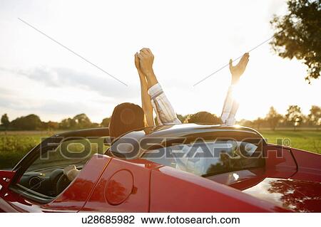 Stock Image - Couple in an electric sports car, fun. Fotosearch