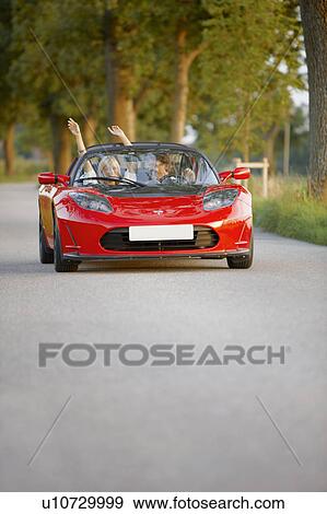 Stock Photo - Couple in an electric sports car, fun. Fotosearch