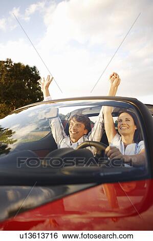 Stock Photograph - Couple in an electric sports car, fun. Fotosearch