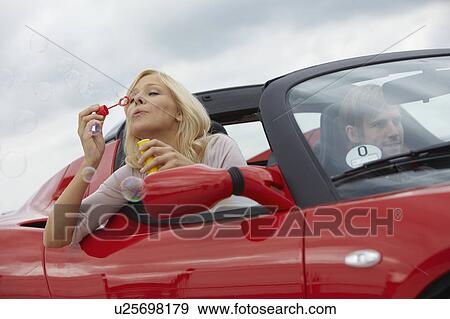 Couple in electric car, blowing bubbles View Large Photo Image Stock Photo - Couple in electric car, blowing bubbles. Fotosearch
