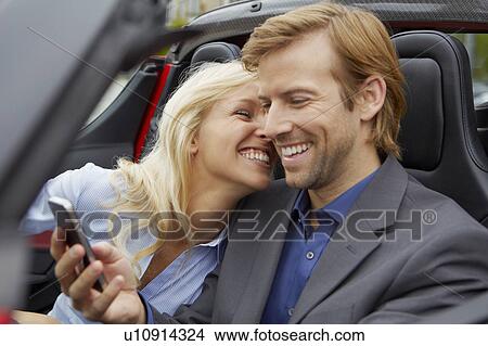 Couple in their electric sports car, fun View Large Photo Image Picture - Couple in their electric sports car, fun. Fotosearch