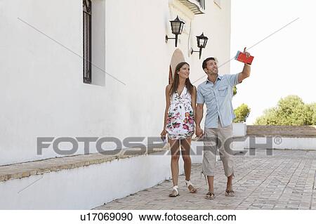 Stock Image - Couple looking at tourist attractions. Fotosearch