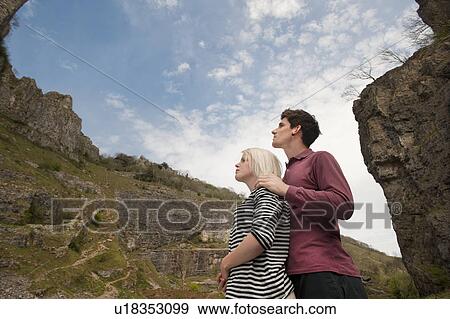 Stock Photo - Couple looking up in valley. Fotosearch