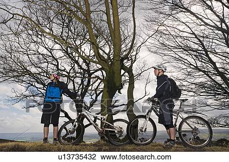 Couple mountain biking in countryside View Large Photo Image Stock Image - Couple mountain biking in countryside. Fotosearch