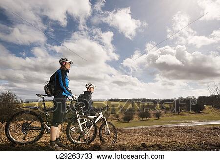 Couple mountain biking in countryside View Large Photo Image Stock Image - Couple mountain biking in countryside. Fotosearch